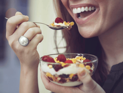 close up image of a woman eating a parfait