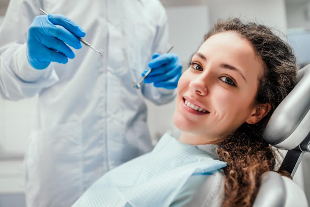 Smiling young woman receiving dental checkup. close up view.
