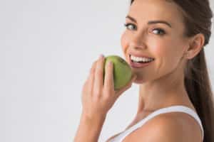 Woman with apple smiling 