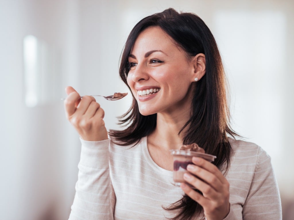 happy-woman-eating-pudding-picture-id1127360342