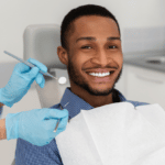 doctor-hands-and-cheerful-african-guy-in-dentist-chair