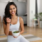 Young-woman-eating-a-healthy-salad-after-workout.