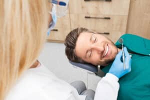 Man smiles during teeth cleaning in Golden, CO