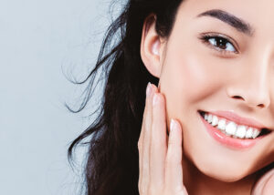 Brunette woman flashes a bright white smile following professional teeth whitening treatment in Golden, CO
