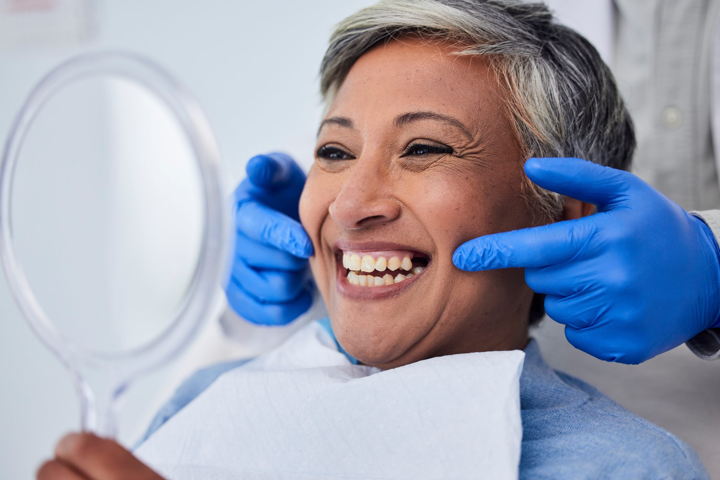 Senior woman with gray hair has a big smile after seeing her restorative dental work