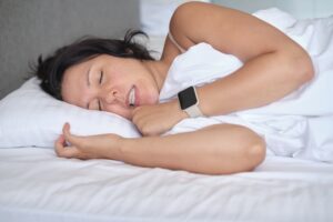 Woman clenches her jaw while in bed